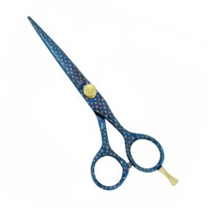 Professional stainless steel hair cutting shears completely coated in a decorative metallic royal blue finish with an intricate gold geometric diamond and dot mosaic pattern, featuring a raised gold adjustment tension knob, an integrated finger rest, and a bumper silencer, shown in 20.jpg against a clean white background.
